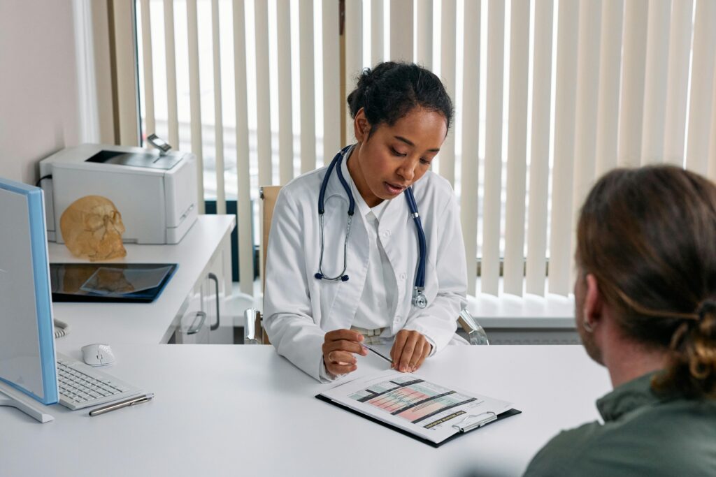 A doctor reads from a chart as her patient, opposite, listens