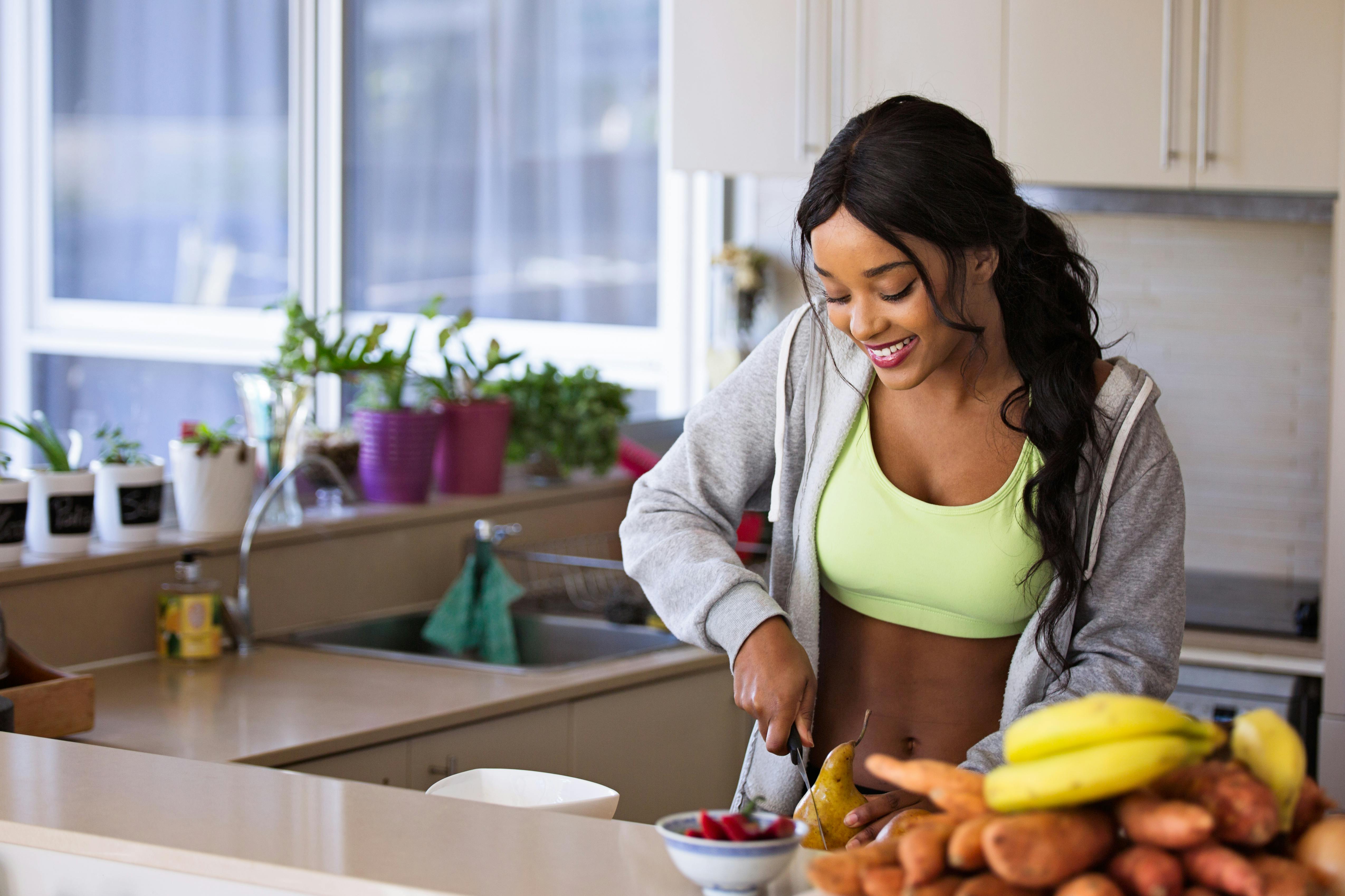 A woman smiling whilst preparing food