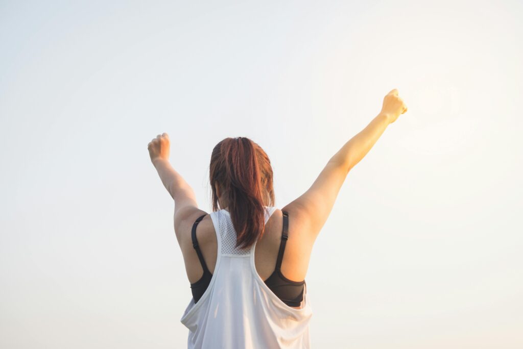 A woman celebrating, photographed from behind