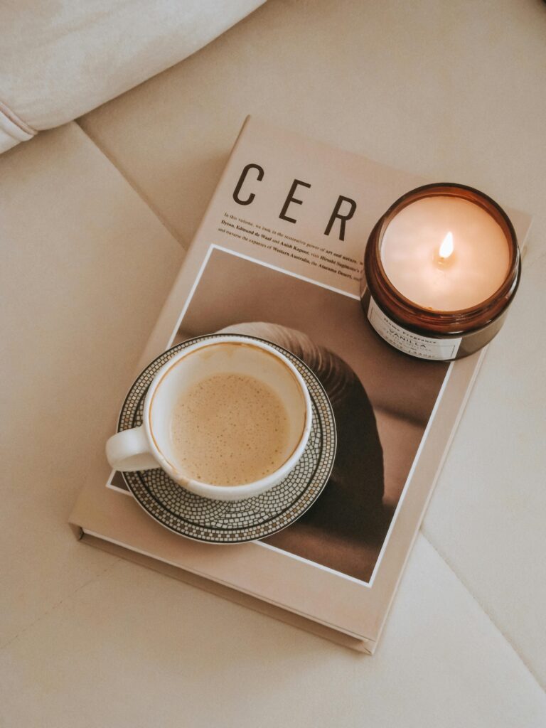 A cop of coffee and a candle on a book